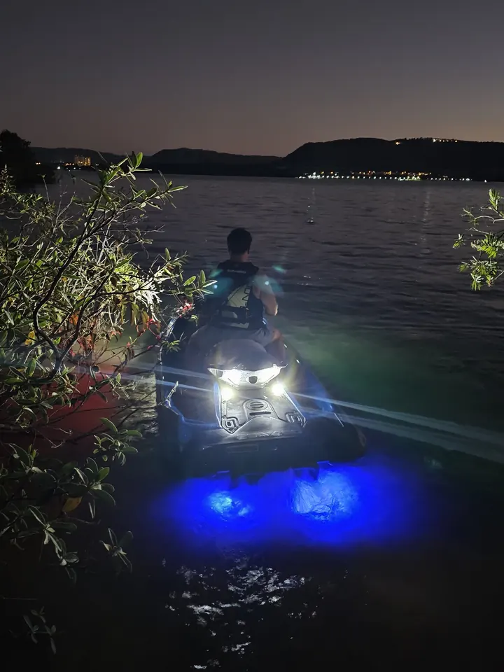Jet ski à noite com todos os LEDs acesos e brilho azul na água
