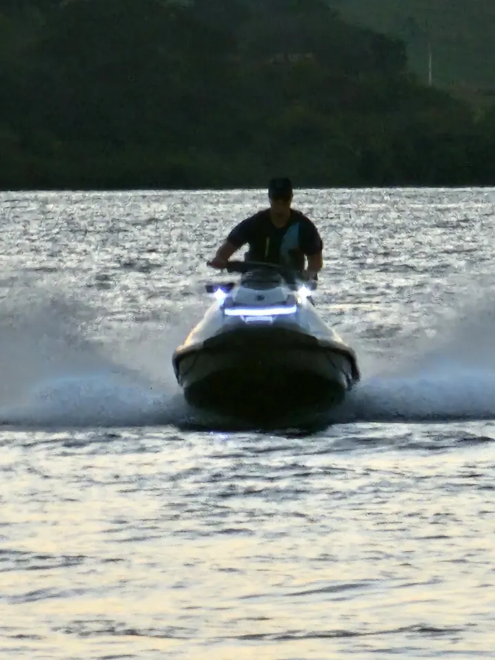 Jet ski em alta velocidade com faixa de LED na proa ao entardecer