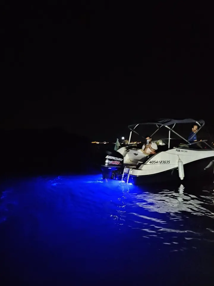 Lancha à noite com luz azul intensa na água
